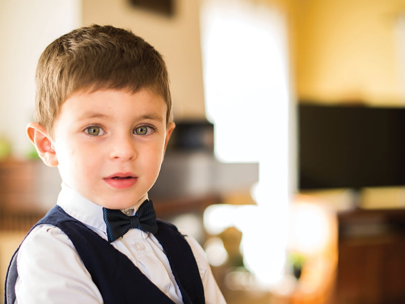 Boy in navy suit and bow tie at wedding