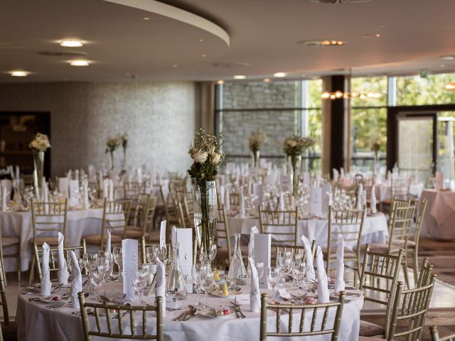 Function room with elegant white design and flowers on the tables