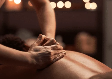 Luxurious spa massage in warm-lit room with relaxing candles, offering ultimate wellness experience.