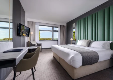 Elegant hotel room with king bed, scenic views, and modern amenities for a comfortable stay.