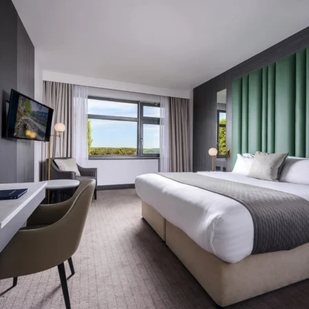 Elegant hotel room with king bed, scenic views, and modern amenities for a comfortable stay.