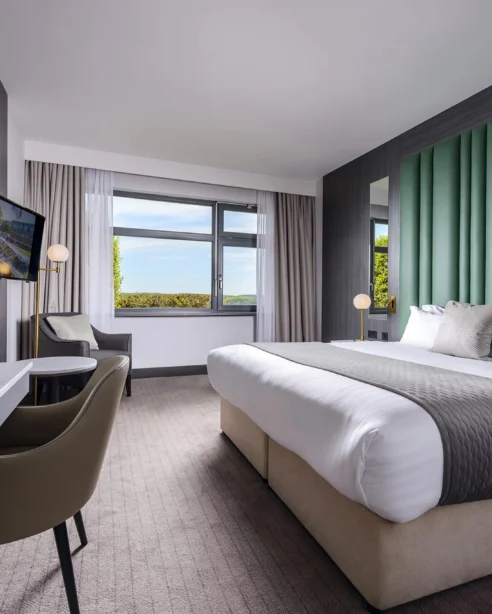 Elegant hotel room with king bed, scenic views, and modern amenities for a comfortable stay.
