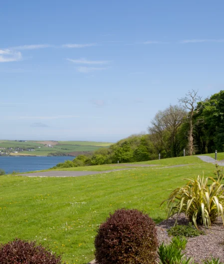 Serene coastal view with lush gardens at a countryside hotel, offering a tranquil escape with modern amenities.