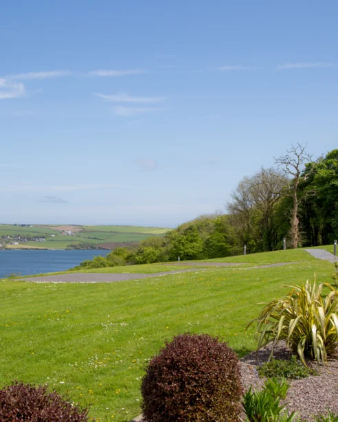 Serene coastal view with lush gardens at a countryside hotel, offering a tranquil escape with modern amenities.