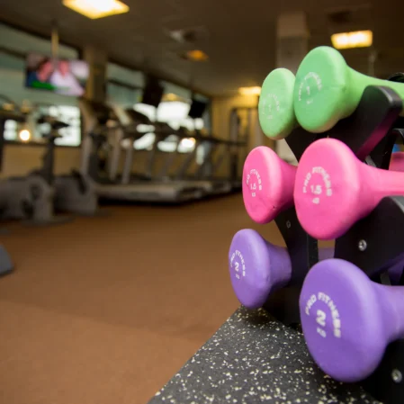 Vibrant hotel gym with colourful dumbbells and treadmills for a complete fitness experience.