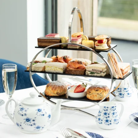Enjoy exquisite afternoon tea with sandwiches and pastries in a stylish hotel dining room with charming decor.