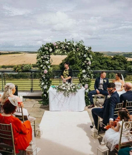Beautiful hotel terrace with stunning countryside views, elegant wedding setup, and lush greenery under a clear blue sky.