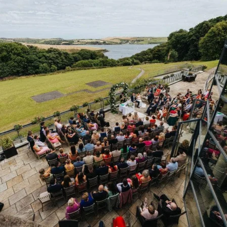 Guests enjoying a scenic outdoor wedding ceremony with countryside views from hotel terrace.