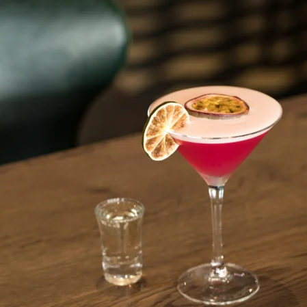 Luxurious cocktail with passion fruit garnish at elegant hotel bar, perfect for a relaxing evening.