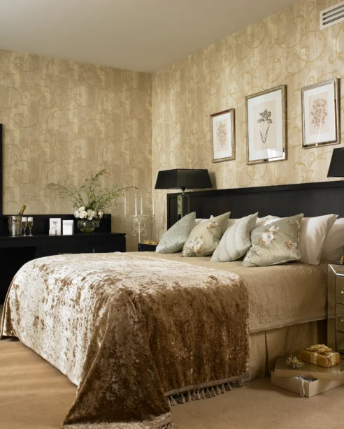 Elegant hotel room with king-size bed, plush pillows, chic decor, large mirror, and ambient lighting for a luxurious stay.