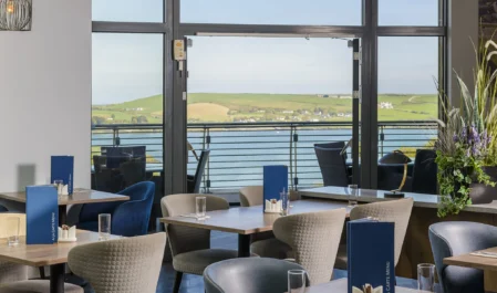 Relaxing hotel dining with scenic seaside view, elegant seating, and modern decor, perfect for a tranquil retreat.