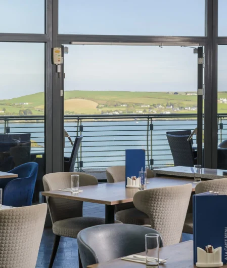 Relaxing hotel dining with scenic seaside view, elegant seating, and modern decor, perfect for a tranquil retreat.