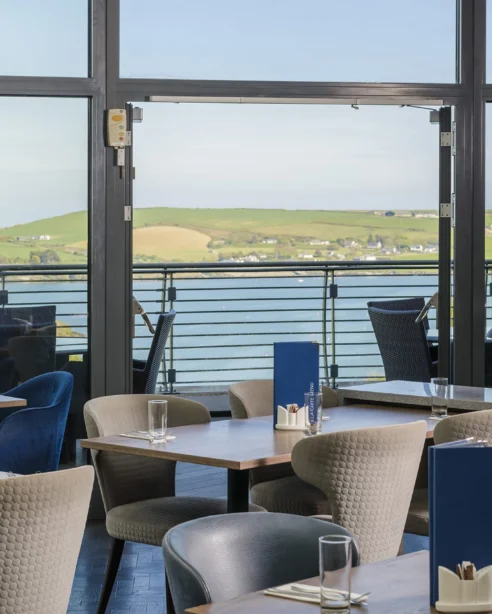Relaxing hotel dining with scenic seaside view, elegant seating, and modern decor, perfect for a tranquil retreat.