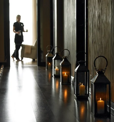 Romantic corridor with dim lanterns and soft lighting, offering a serene walk to luxurious hotel suites.