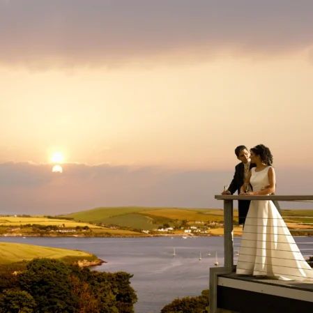 Couple enjoys a romantic sunset over serene coastal views from hotel balcony, perfect for a relaxing and memorable getaway.