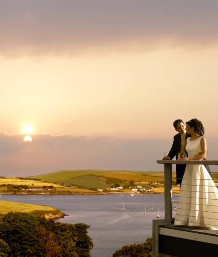 Couple enjoys a romantic sunset over serene coastal views from hotel balcony, perfect for a relaxing and memorable getaway.