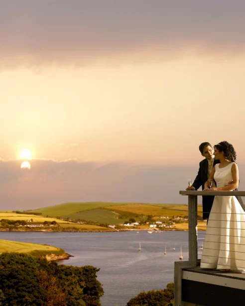 Couple enjoys a romantic sunset over serene coastal views from hotel balcony, perfect for a relaxing and memorable getaway.