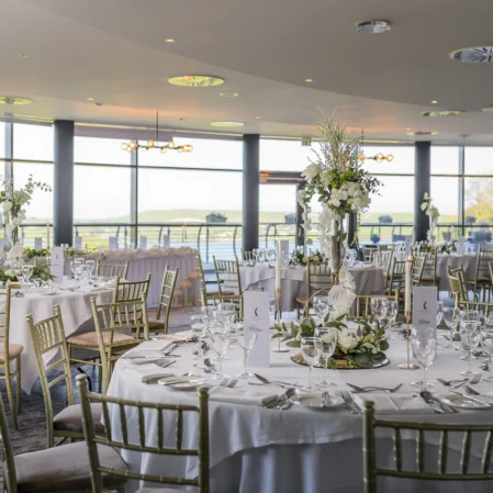 Elegant hotel banquet hall with panoramic views, stylish decor, and finely set tables for a luxurious dining experience.