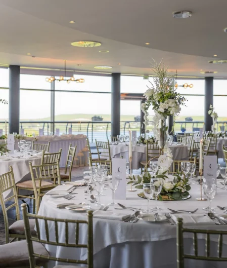 Elegant hotel banquet hall with panoramic views, stylish decor, and finely set tables for a luxurious dining experience.