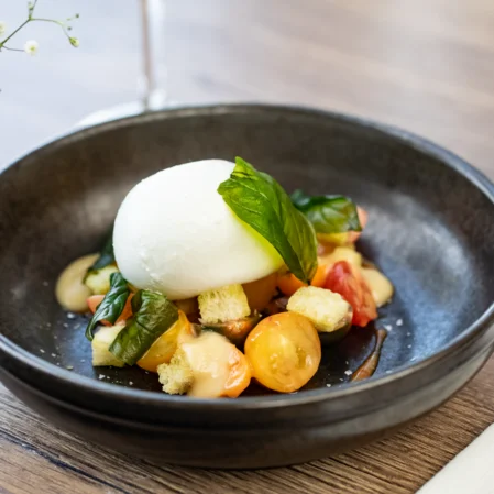 Savour fresh burrata salad with tomatoes and basil at our luxury hotel restaurant.