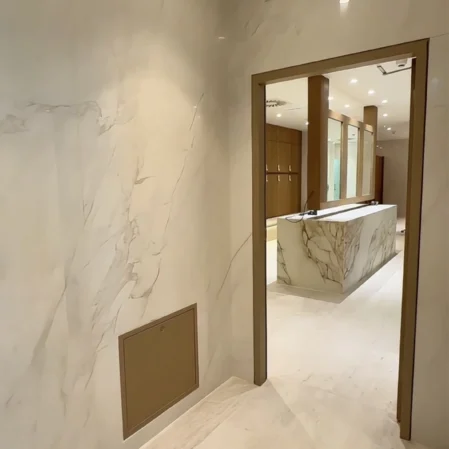Luxurious hotel marble corridor leading to elegant reception area with modern design and inviting lighting.