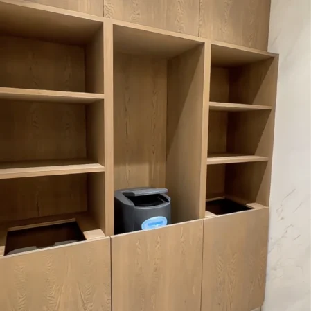 Elegant wooden shelves in hotel lobby with modern ice dispenser, perfect for guest convenience and comfort.