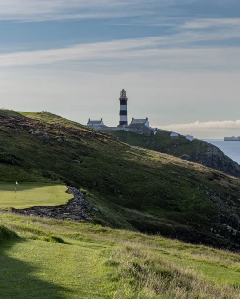 Scenic coastal view with a lighthouse near a golf course, perfect for relaxation and leisure activities at the hotel.