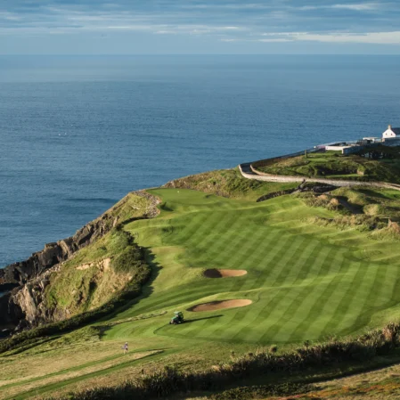Picturesque coastal golf course with ocean views and historic lighthouse, ideal for relaxing seaside getaways.