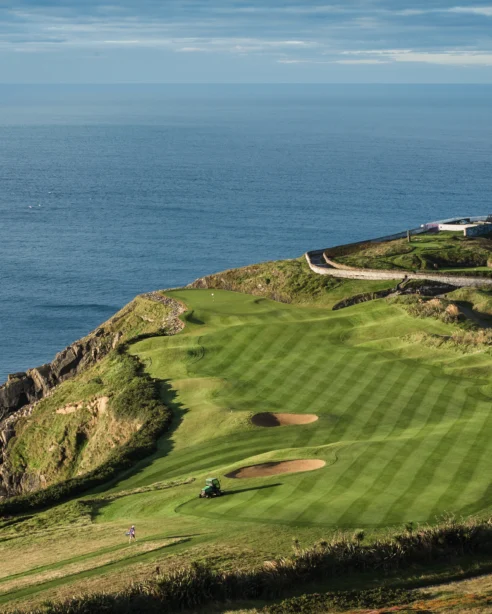 Picturesque coastal golf course with ocean views and historic lighthouse, ideal for relaxing seaside getaways.