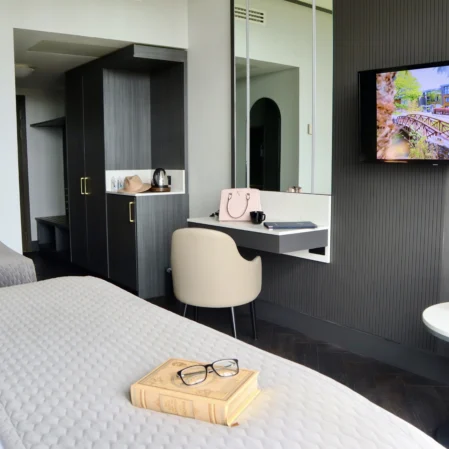 Elegant hotel room with plush bedding, smart TV, and chic workspace, offering a cosy and modern guest experience.
