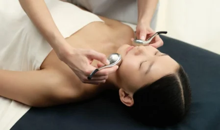 Guest enjoying a soothing facial treatment at luxury spa, featuring plush massage table and calming ambience.