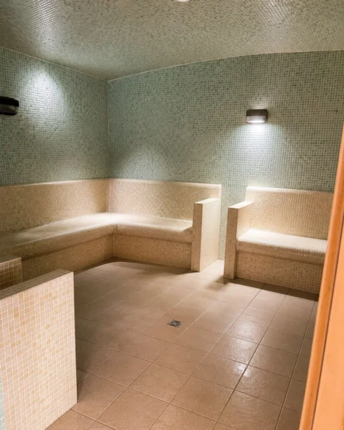 Luxurious hotel steam room with cosy seating and ambient lighting for relaxation and rejuvenation.