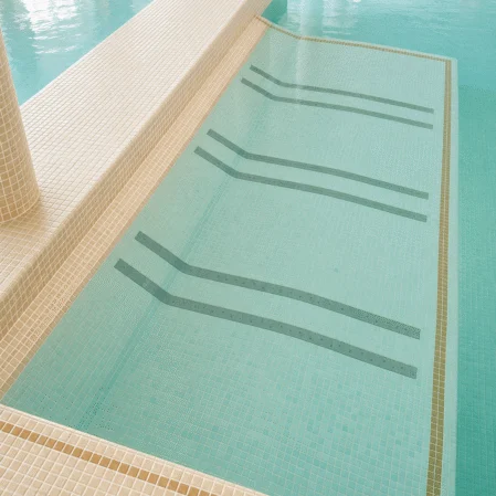 Luxurious indoor pool with serene turquoise waters and elegant tiled edges for a relaxing hotel experience.