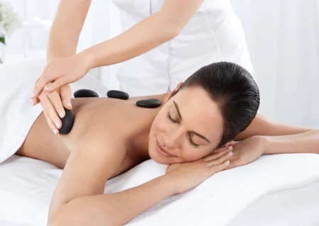 Guest enjoying soothing hot stone massage in serene hotel spa, enhancing relaxation and wellness experience.
