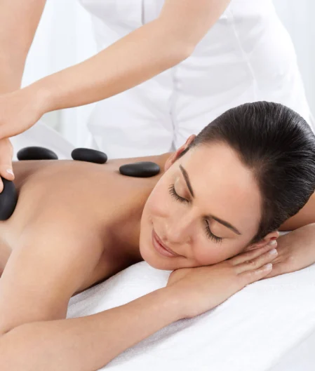 Guest enjoying soothing hot stone massage in serene hotel spa, enhancing relaxation and wellness experience.