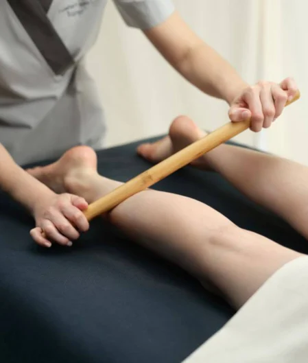 Relaxing bamboo massage therapy at luxury hotel spa, focusing on leg rejuvenation.